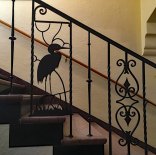 A heron embellishes the wrought iron staircase railing.